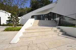 Villa in Berlin mit Terrasse und Wege- und Gartenplatten aus beigem Travertion Bauhaus von TRACO