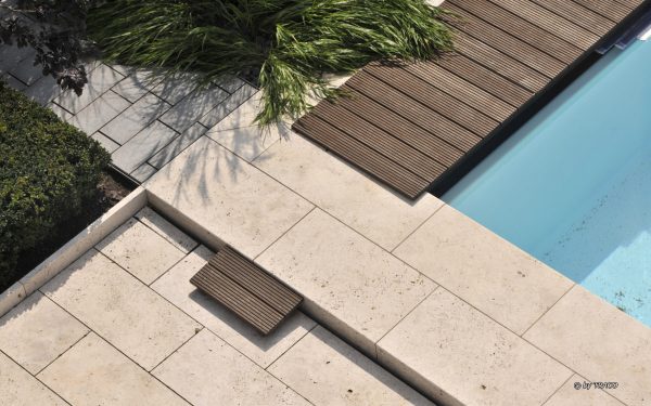 Terrassenbelag und Pool-Einfassung aus beigem Travertin Bauhaus von TRACO
