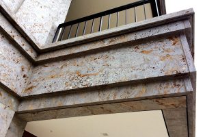 Detailansicht auf ein Wohnhaus am Mannesmannufer in Düsseldorf mit dreidimensionaler Natursteinfassade aus grauem Mooser Muschelkalk von TRACO