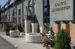 Außenansicht der TRACO Manufactur Ausstellung mit Pflanztrögen im Vordergrund