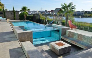 Pool, Sitzelemente, Feuerstelle und Terrassenplatten aus Limes Dolomit®