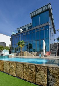 Villa mit Pool, Terrassenplatten und einer Wandverkleidung aus Limes Dolomit®