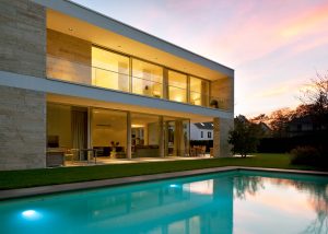 Villa mit einer massiven Natursteinfassade aus Bauhaus Travertin von TRACO
